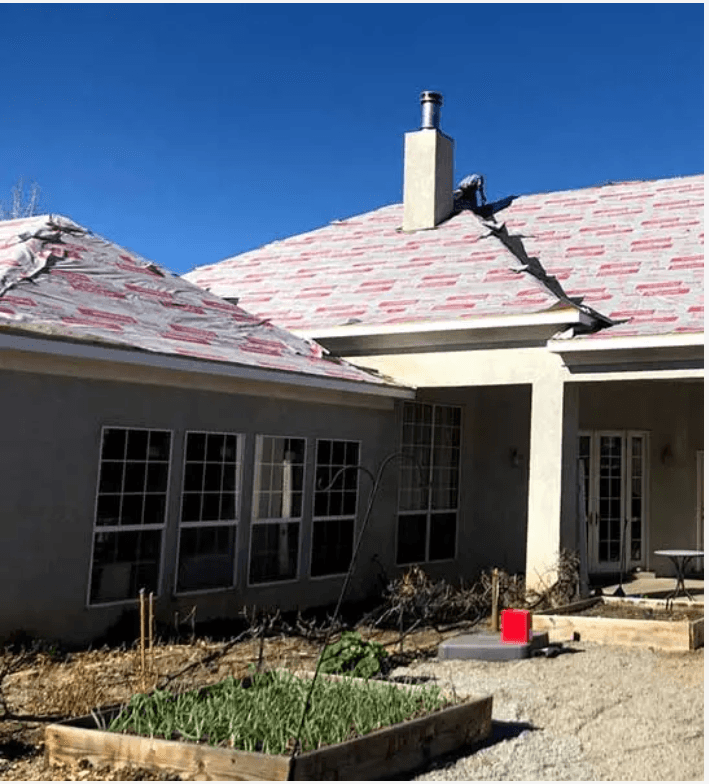 Roof tear-off in progress — underlayment visible during shingle replacement